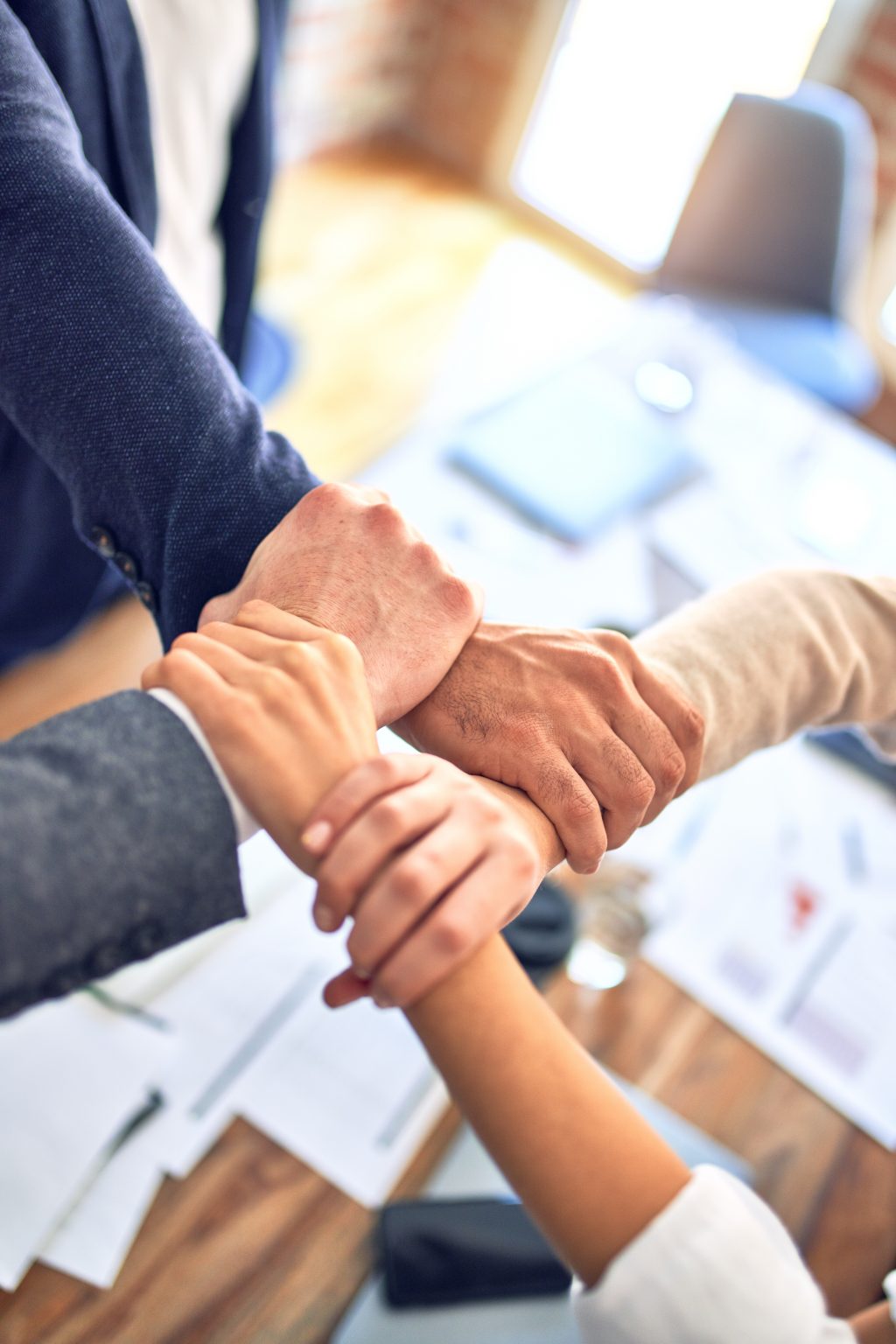 Equipo uniendo las manos en señal de trabajo conjunto
